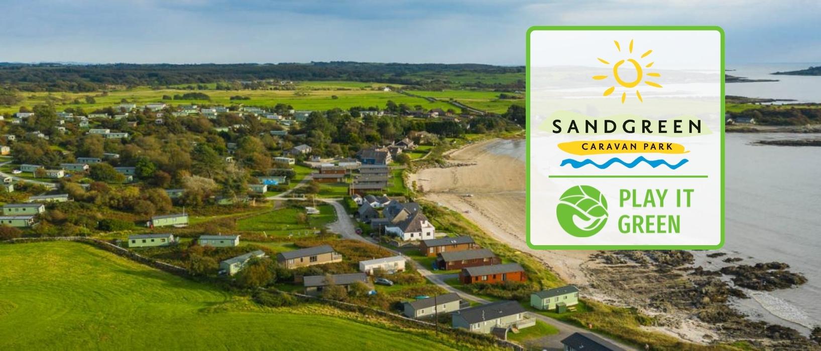 aerial view of small caravan park next to coast, Play it Green and Sandgreen Caravan Park logos placed together in front